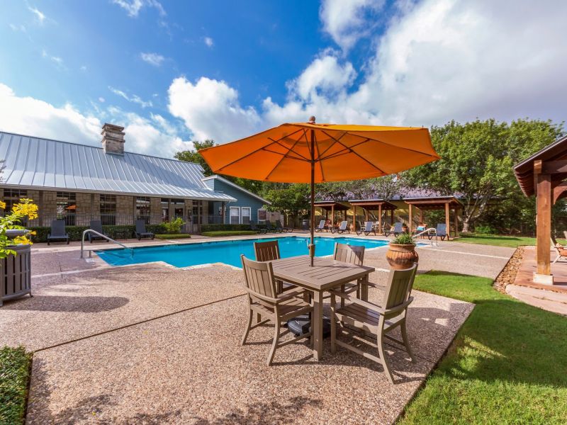 Elm Hollow apartments pool with patio table and umbrella