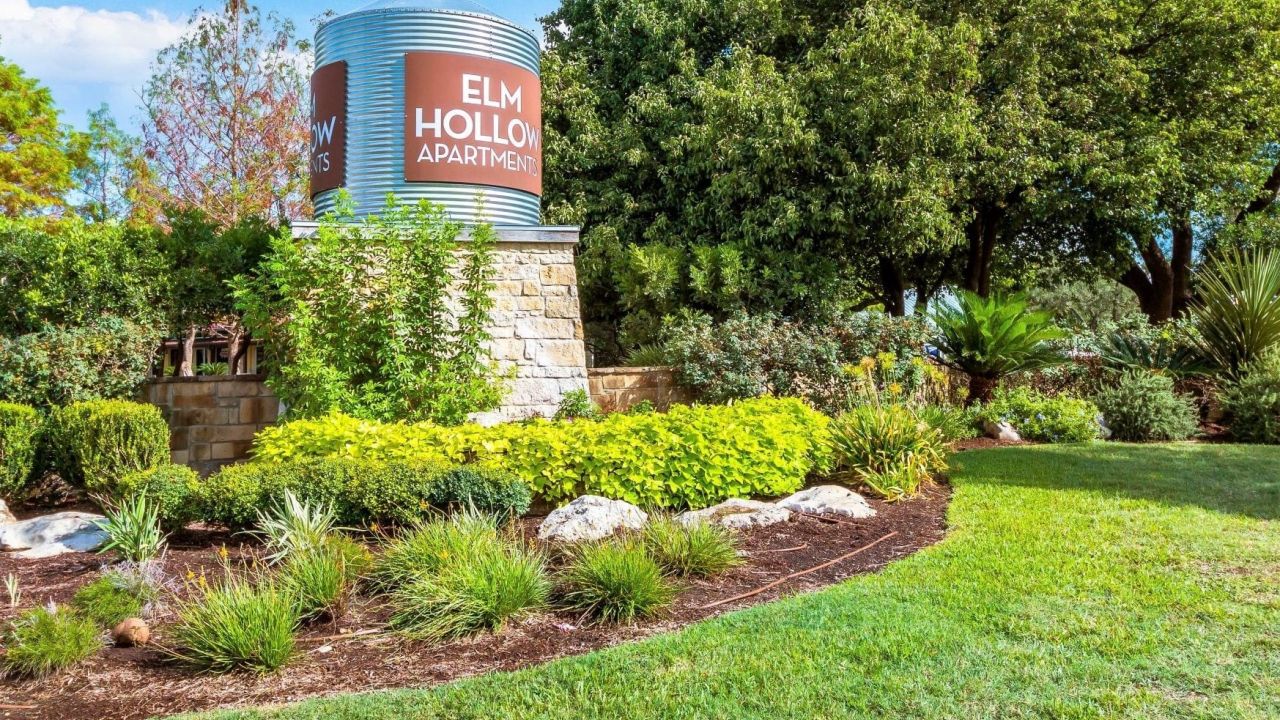 Elm Hollow apartments exterior sign with beautiful landscaping