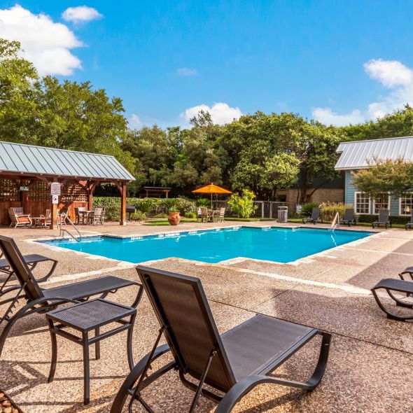 Elm Hollow Apartments beautiful pool amenity with lounge chairs and seating around the pool